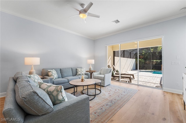 living room featuring light wood-type flooring, ceiling fan, and ornamental molding