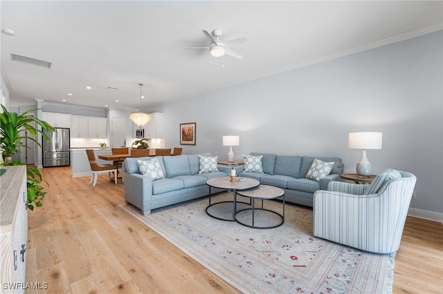 living room featuring ceiling fan, light hardwood / wood-style flooring, and ornamental molding