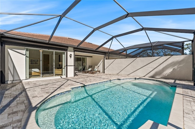 view of swimming pool featuring glass enclosure and a patio area