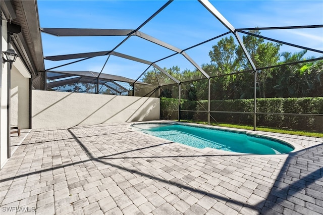 view of pool featuring a patio area and glass enclosure