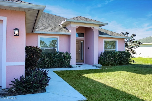 view of exterior entry featuring a yard