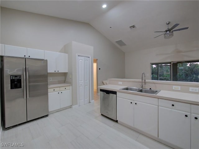 kitchen featuring white cabinets, stainless steel appliances, lofted ceiling, and sink