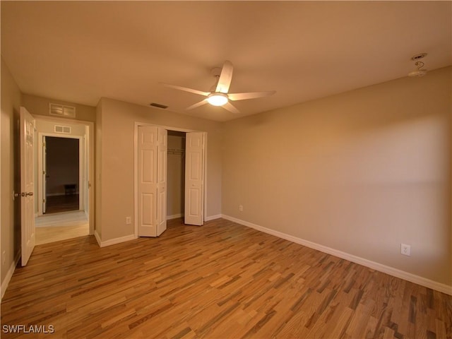 unfurnished bedroom featuring ceiling fan, a closet, and light hardwood / wood-style floors