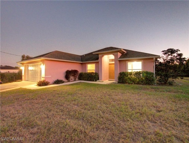 view of front of home featuring a garage and a lawn