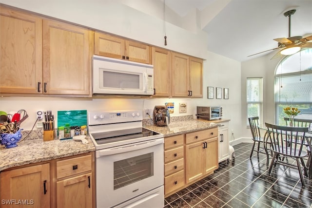 kitchen featuring white appliances, light stone countertops, light brown cabinetry, lofted ceiling, and ceiling fan