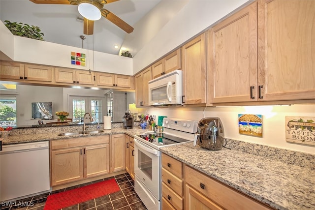 kitchen featuring white appliances, vaulted ceiling, sink, and light brown cabinets