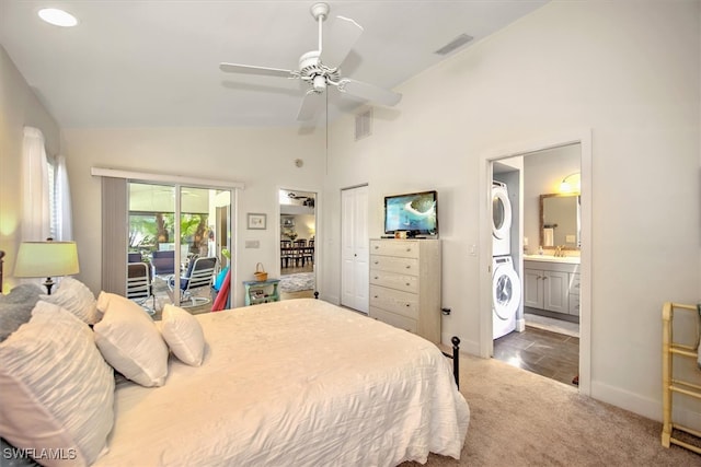 bedroom with stacked washer / dryer, lofted ceiling, connected bathroom, ceiling fan, and dark colored carpet