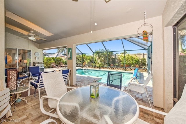 view of pool featuring ceiling fan, glass enclosure, and a patio area