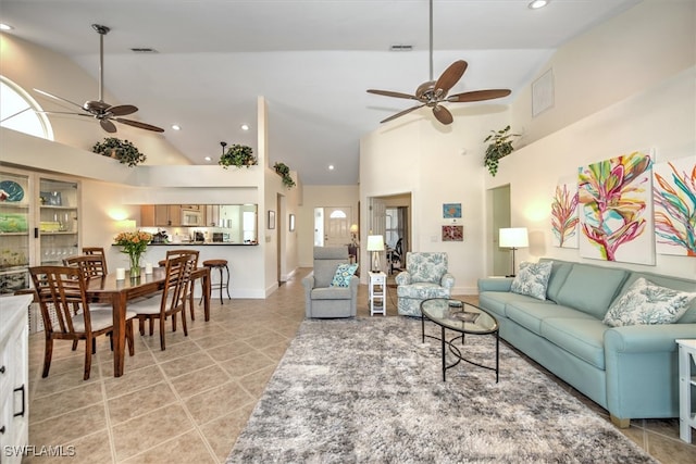 living room with high vaulted ceiling, ceiling fan, light tile patterned floors, and plenty of natural light