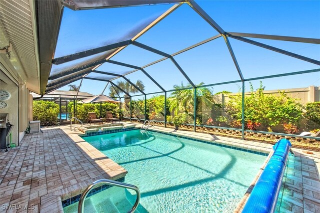 view of pool featuring a patio and glass enclosure