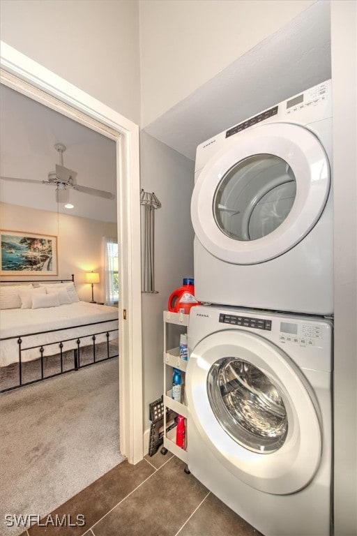 laundry room with ceiling fan, stacked washer / drying machine, and dark colored carpet