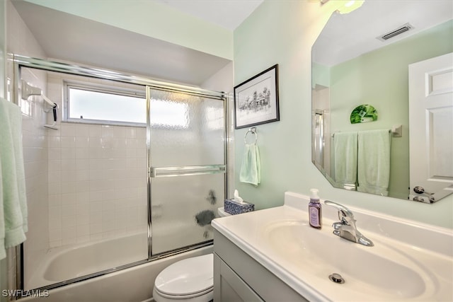 full bathroom with toilet, vanity, and bath / shower combo with glass door