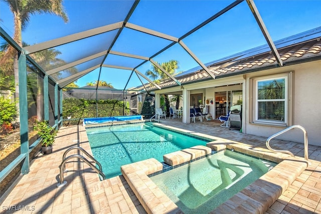 view of pool with glass enclosure, an in ground hot tub, and a patio area