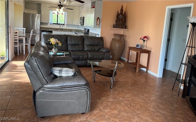 tiled living room featuring ceiling fan and sink