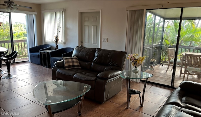 living room with a wealth of natural light, light tile patterned floors, and ceiling fan