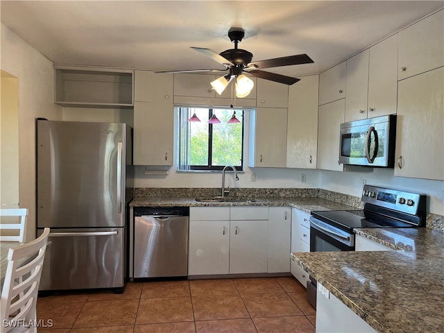 kitchen featuring tile patterned floors, stainless steel appliances, ceiling fan, sink, and white cabinets