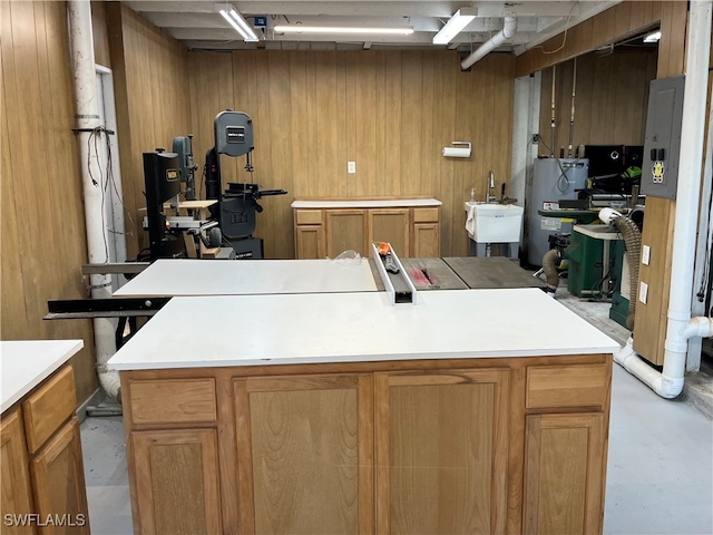 kitchen featuring wood walls, a kitchen island, electric water heater, and electric panel