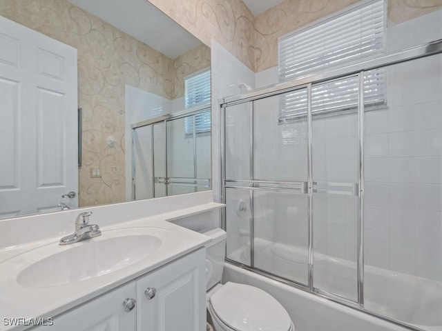 bathroom featuring toilet, wallpapered walls, enclosed tub / shower combo, and vanity