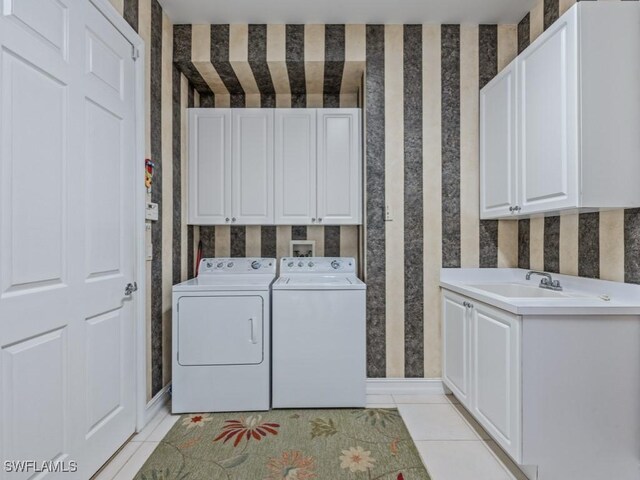 washroom with washer and dryer, sink, light tile patterned floors, and cabinets