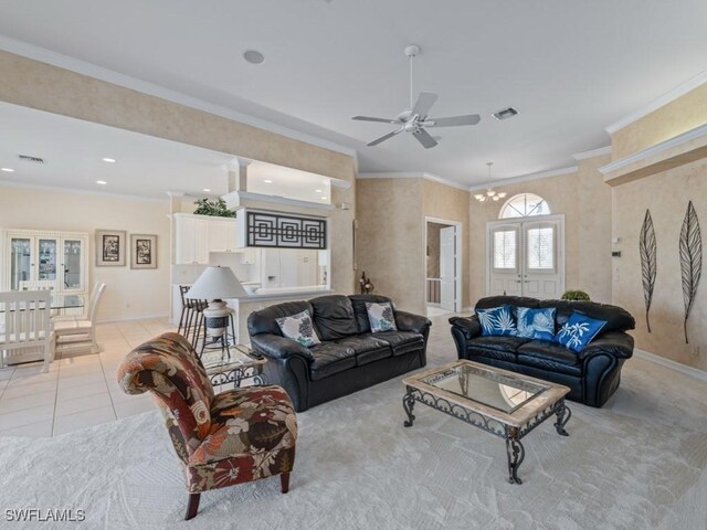 living room featuring light tile patterned floors, ceiling fan with notable chandelier, french doors, and ornamental molding