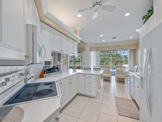 kitchen with kitchen peninsula, white appliances, and white cabinets