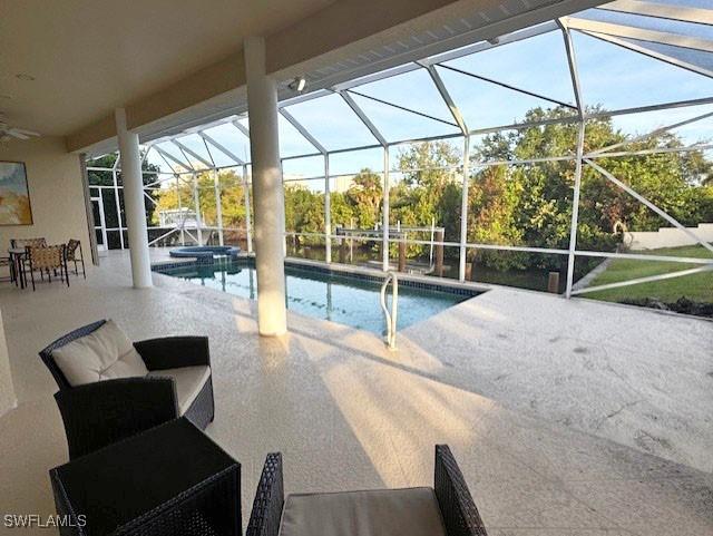 view of swimming pool featuring glass enclosure and a patio