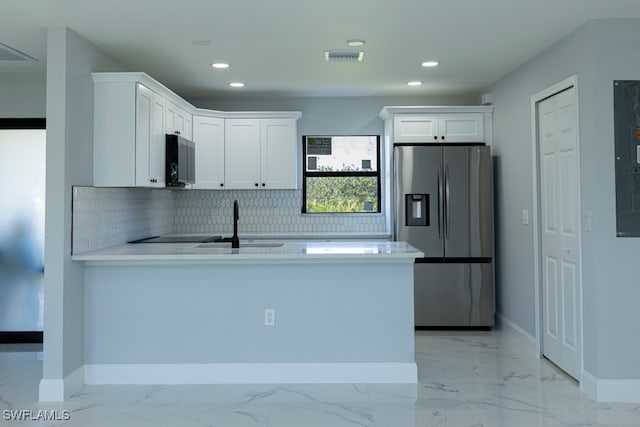 kitchen featuring decorative backsplash, white cabinetry, sink, and stainless steel refrigerator with ice dispenser