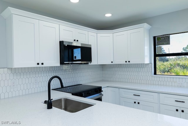 kitchen with white cabinets, sink, and tasteful backsplash