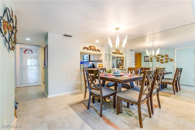 dining area with light tile patterned floors and a chandelier