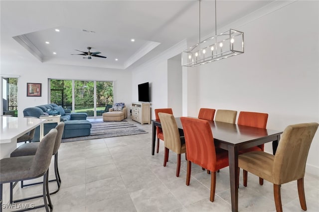 dining room featuring ceiling fan, a raised ceiling, and ornamental molding