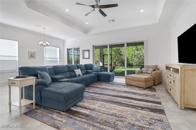 living room featuring ceiling fan with notable chandelier, a raised ceiling, and ornamental molding