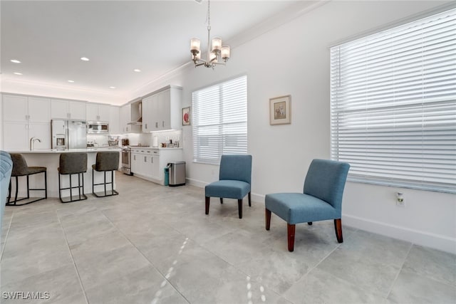 sitting room with a chandelier and ornamental molding