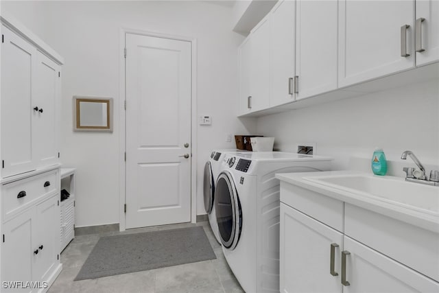 washroom featuring cabinets, light tile patterned floors, sink, and washing machine and clothes dryer