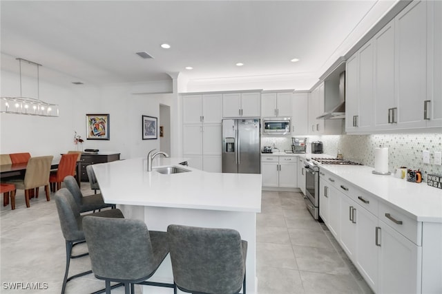 kitchen featuring decorative light fixtures, sink, white cabinetry, and stainless steel appliances