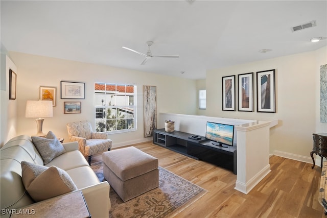 living room featuring light hardwood / wood-style flooring and ceiling fan