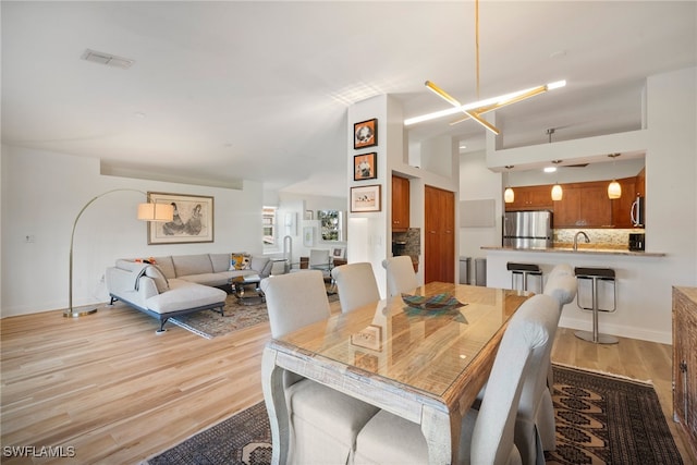 dining space with light hardwood / wood-style flooring and sink