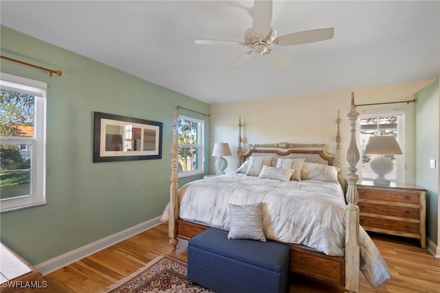 bedroom with hardwood / wood-style flooring, ceiling fan, and multiple windows