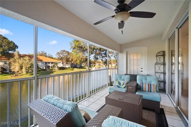 sunroom / solarium with a water view, vaulted ceiling, and ceiling fan