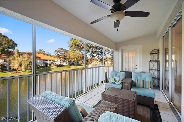 sunroom featuring vaulted ceiling, ceiling fan, and a water view