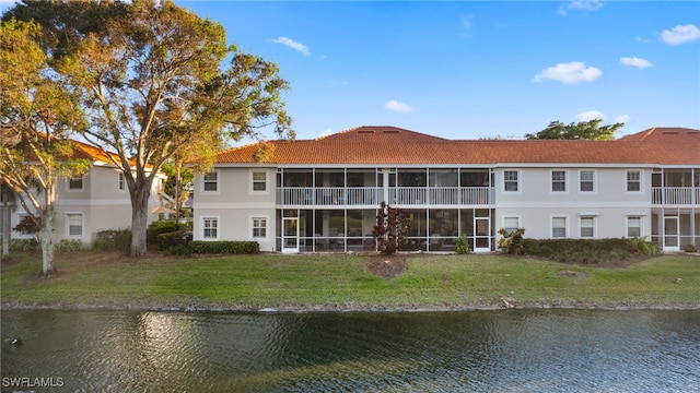 rear view of property featuring a water view and a yard