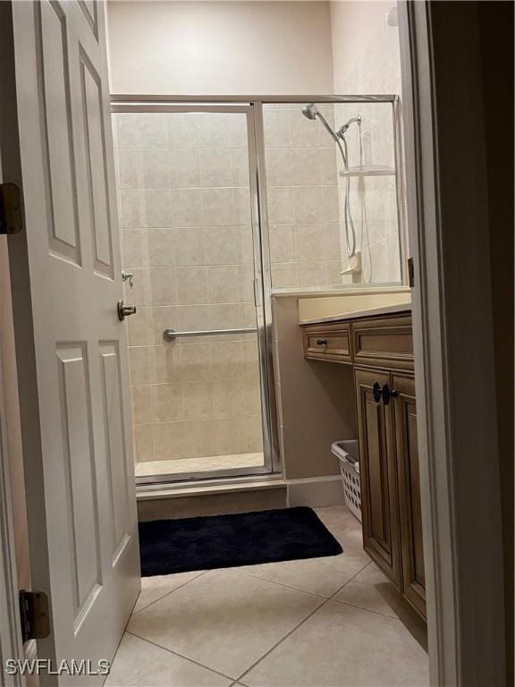 bathroom with tile patterned floors, vanity, and a shower with shower door