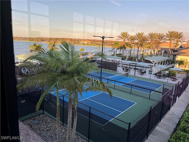 view of tennis court featuring a water view