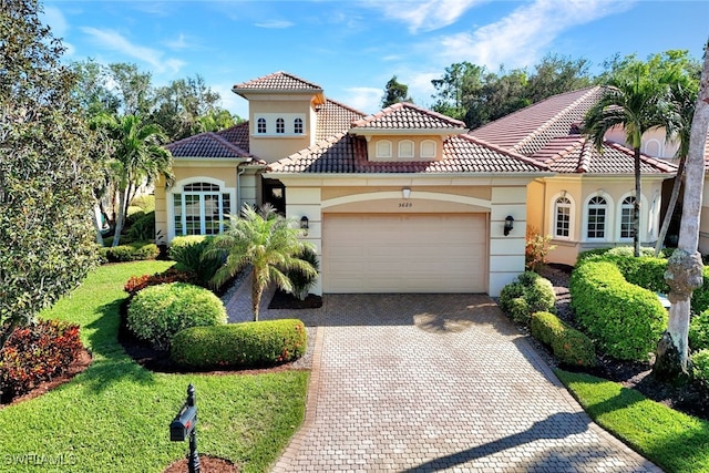 5620 Hammock Isles Dr, Naples, FL 34119 - mediterranean / spanish-style home featuring a garage, stucco siding, decorative driveway, and a tile roof