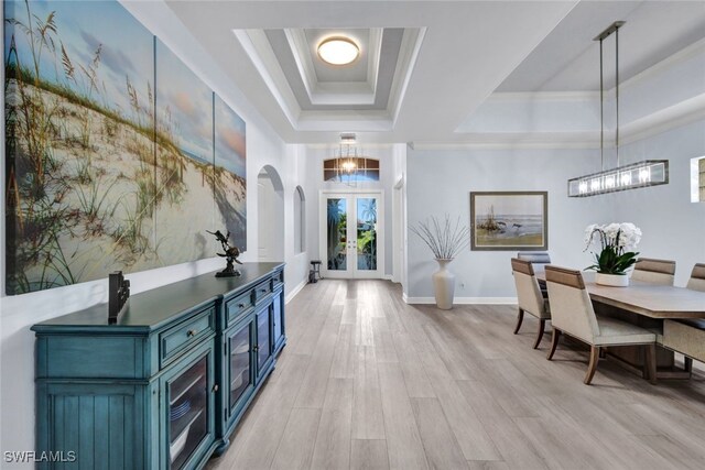 5620 Hammock Isles Dr, Naples, FL 34119 - entrance foyer featuring a tray ceiling, arched walkways, french doors, light wood-type flooring, and a chandelier