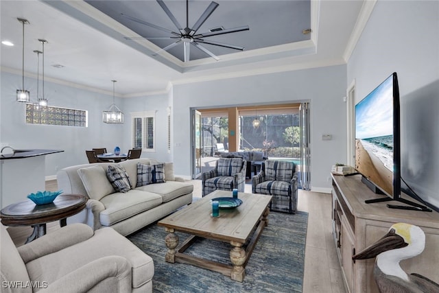 5620 Hammock Isles Dr, Naples, FL 34119 - living area featuring wood finished floors, a chandelier, a tray ceiling, and crown molding