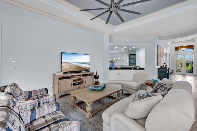 5620 Hammock Isles Dr, Naples, FL 34119 - living room with a chandelier, crown molding, wood finished floors, a raised ceiling, and french doors
