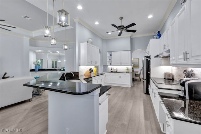 kitchen featuring kitchen peninsula, white cabinets, pendant lighting, and light wood-type flooring