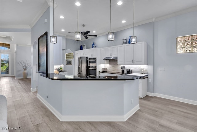 5620 Hammock Isles Dr, Naples, FL 34119 - kitchen with under cabinet range hood, a ceiling fan, dark countertops, ornamental molding, and stainless steel fridge