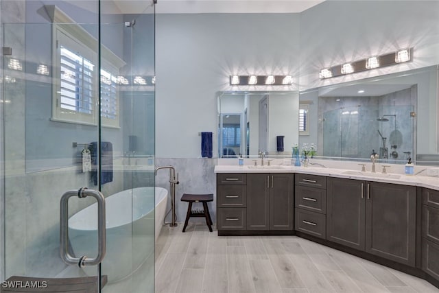 5620 Hammock Isles Dr, Naples, FL 34119 - bathroom with a stall shower, a freestanding tub, tile walls, and double vanity