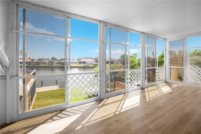 unfurnished sunroom featuring a water view and plenty of natural light